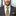 Man wearing a suit with a yellow and black striped tie in an office setting