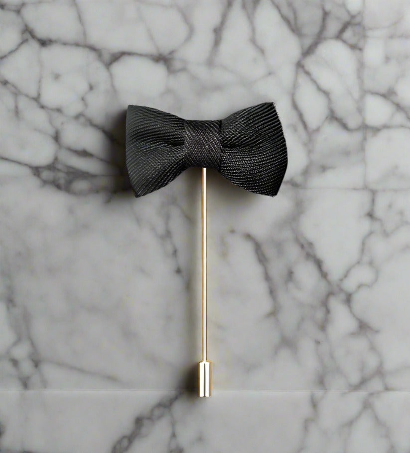 A Deep Charcoal Colored Bow Tie Shaped Lapel Pin||Deep Charcoal