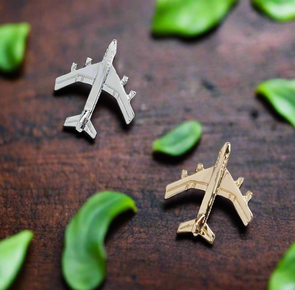 Showing two airplane shaped lapel pins: gold and silver