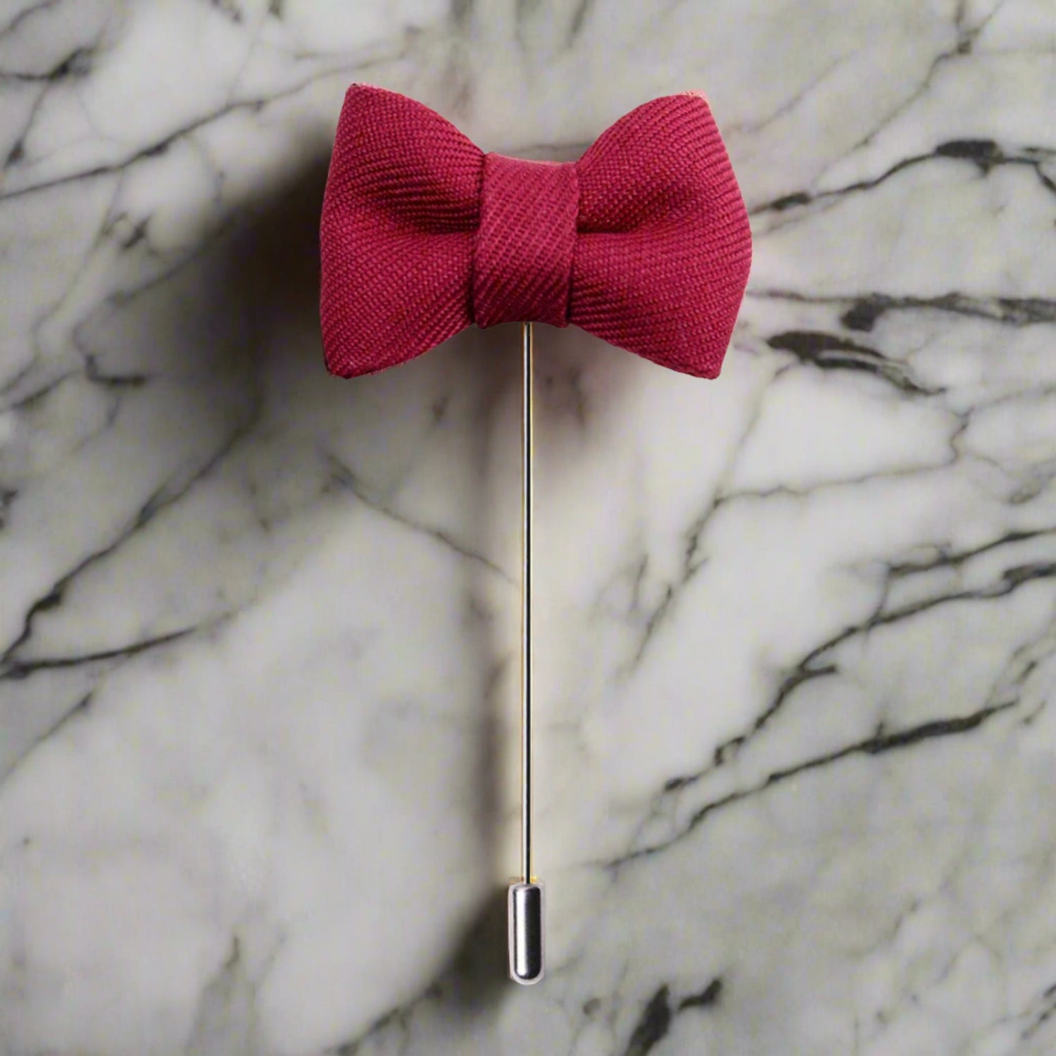 A Red Colored Bow Tie Shaped Lapel Pin||Light Red