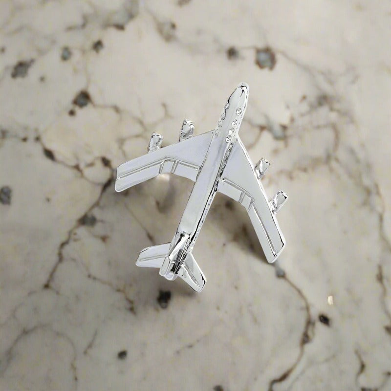 A Silver Colored Airplane Shaped Lapel Pin||Silver