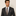 Man wearing a dark suit with a patterned tie and pocket square on a beige background