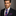 Man wearing a dark suit with a Red and Blue Plaid Tie and Pocket Square