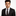 Man wearing a black suit with a patterned tie and pocket square on a white background