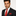 Man wearing a black suit with a red tie and pocket square on a white background