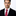 Man wearing a black suit with a red tie on a white background