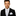 Man wearing a black suit with a colorful tie and pocket square on a white background