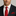 Man wearing a black suit with a red tie and pocket square on a gray background