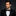 Man wearing a black tuxedo with a bow tie against a dark background