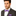 Man wearing a gray suit with a purple patterned bow tie and pocket square on a white background