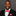 Man wearing a black suit with a red paisley bow tie and pocket square on a gray background