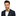 Man wearing a navy suit with a gold geometric bow tie and accenting black and gold polka square on a white background
