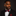 Man wearing a black suit with a red and black stripe and floral bow tie and pocket square on a dark background