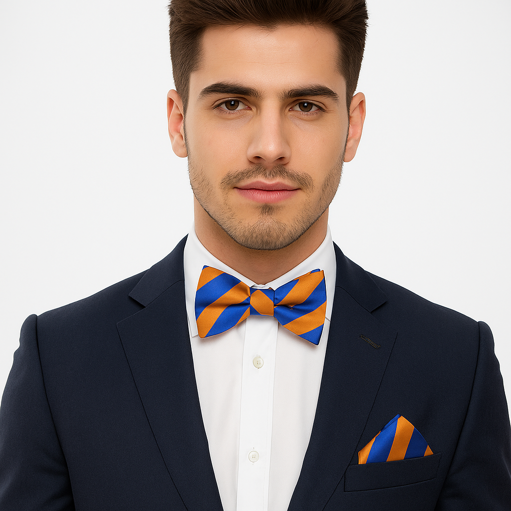 Man wearing a navy suit with an orange and blue stripe bow tie and pocket square on a white background