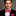 Man wearing a black suit with a pink bow tie and pocket square on a gray background