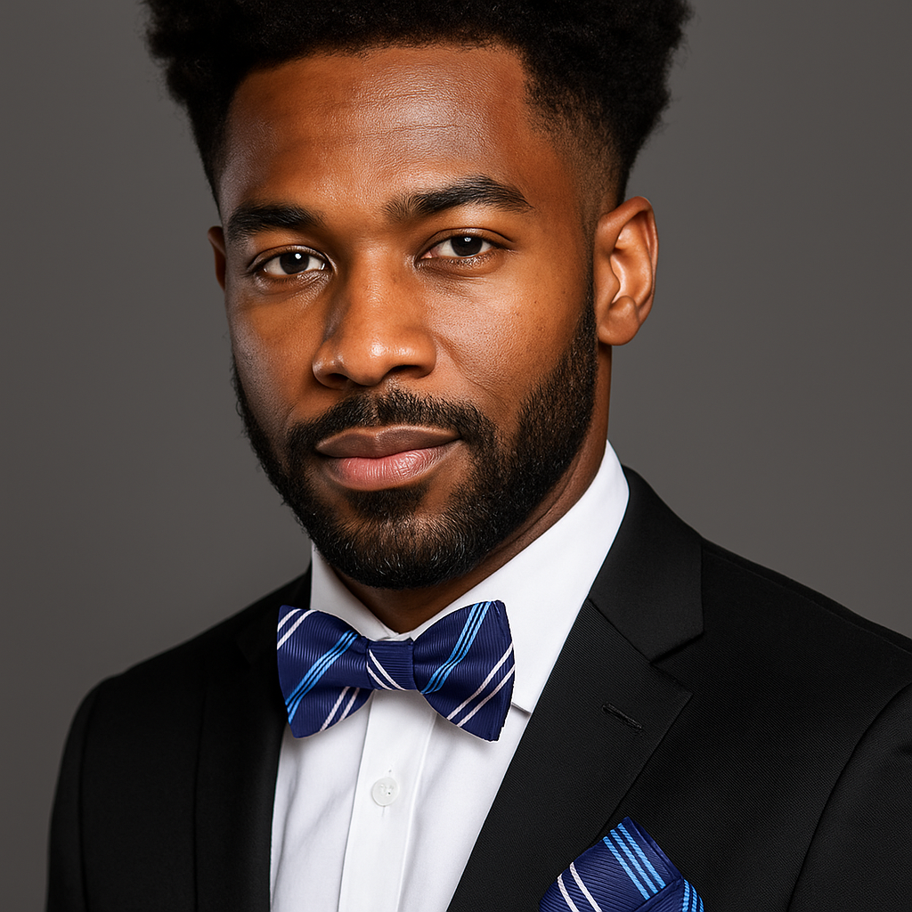 Man wearing a black suit with a white shirt and blue striped bow tie against a gray background