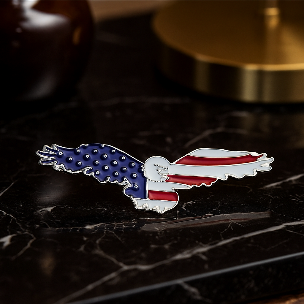 Eagle-shaped pin with American flag design on a dark surface
