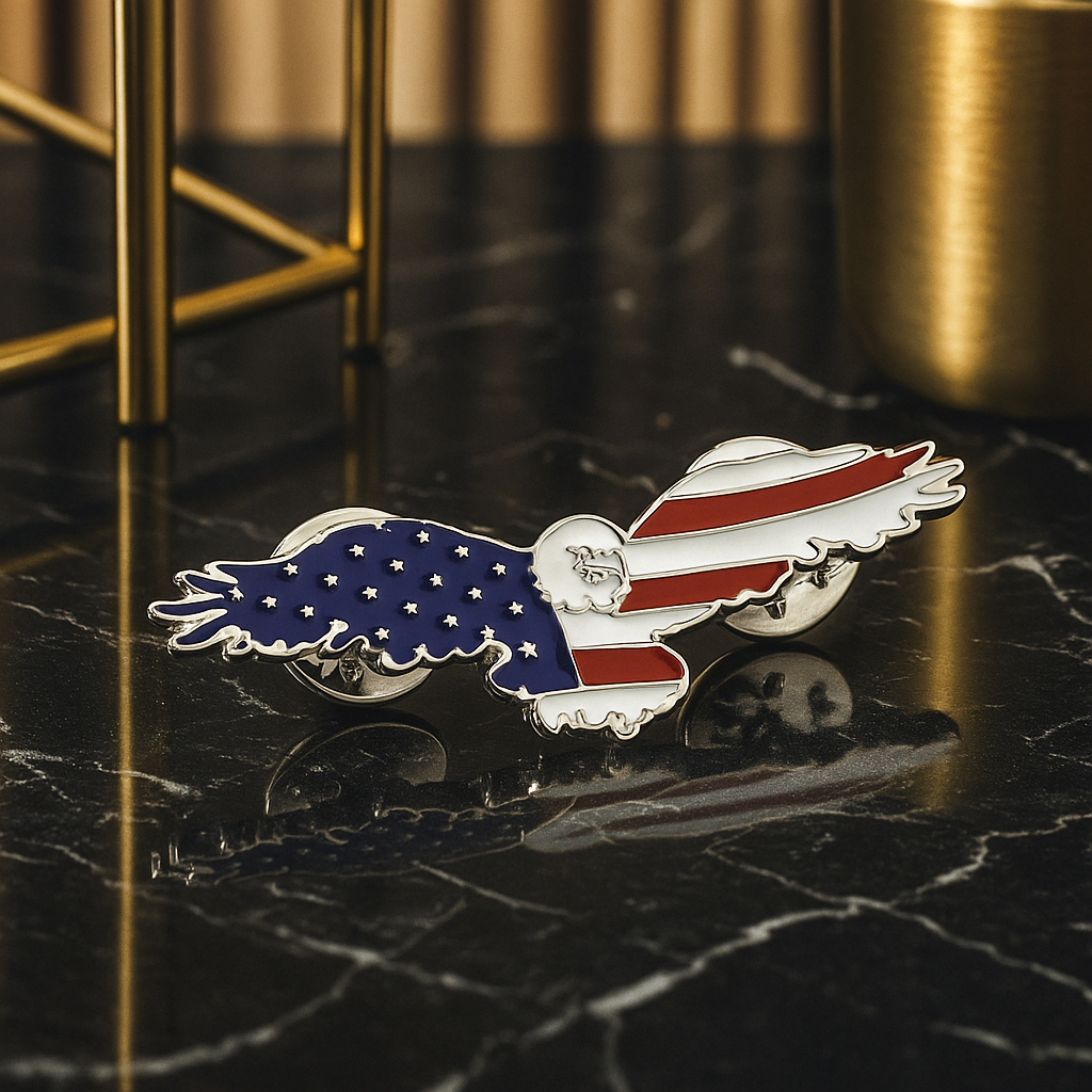 Eagle-shaped pin with American flag design on a dark marble surface