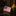 American flag lapel pin on a reflective surface with a blurred background