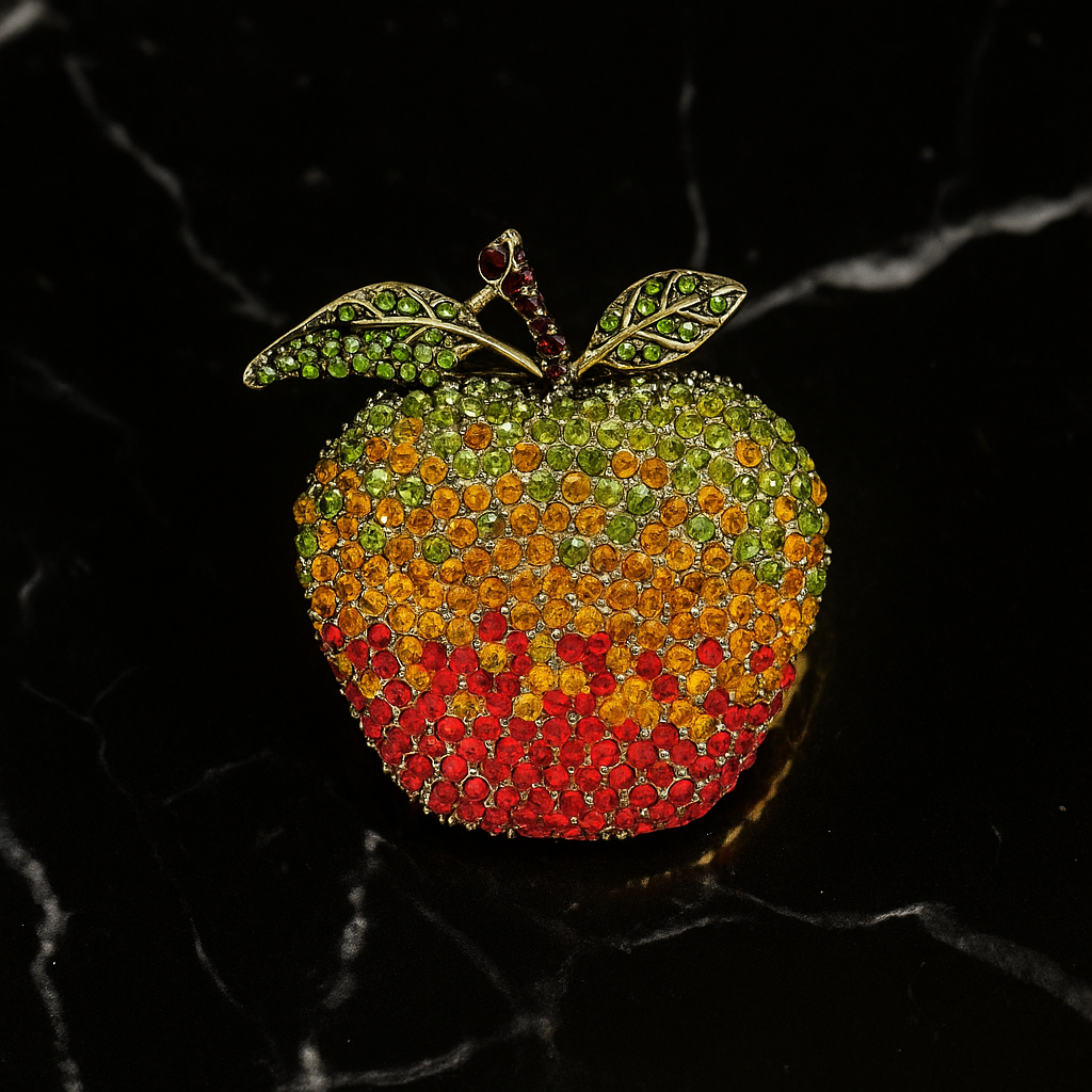 Colorful apple-shaped brooch with gemstones on a black background