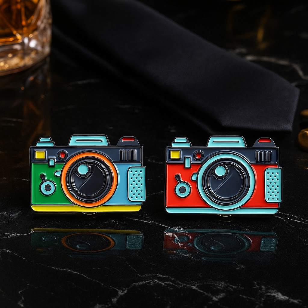 Two brightly colored camera lapel pins.