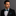 Man wearing a black suit with a Black, Teal Lines Bow Tie and Pocket Square against a gray background