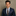 Man wearing a navy suit with a colorful tie against a neutral background