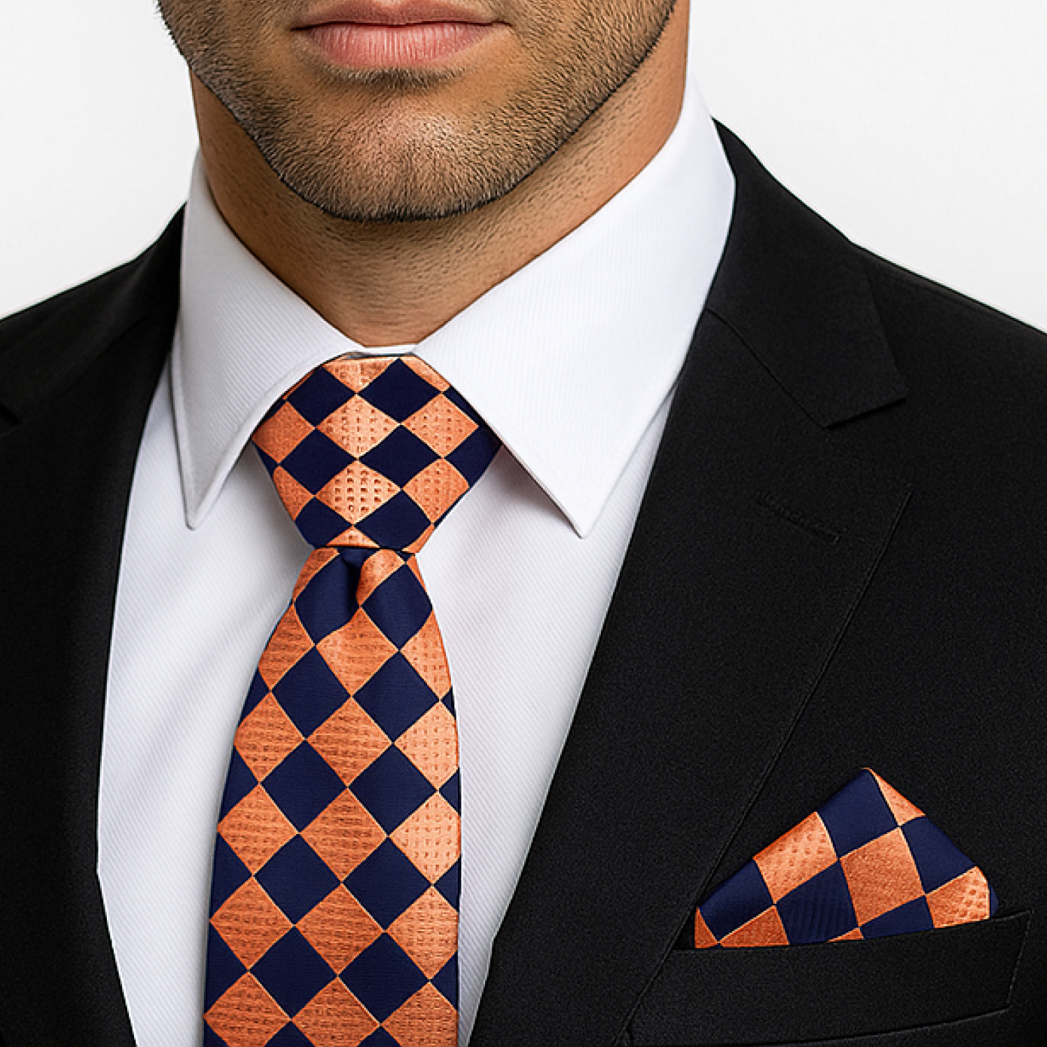 Man wearing a black suit with an orange and black checkered tie and pocket square.