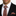 Man wearing a black suit with an orange and black checkered tie and pocket square.