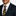 Man wearing a dark suit with a colorful tie and green pocket square on a white background