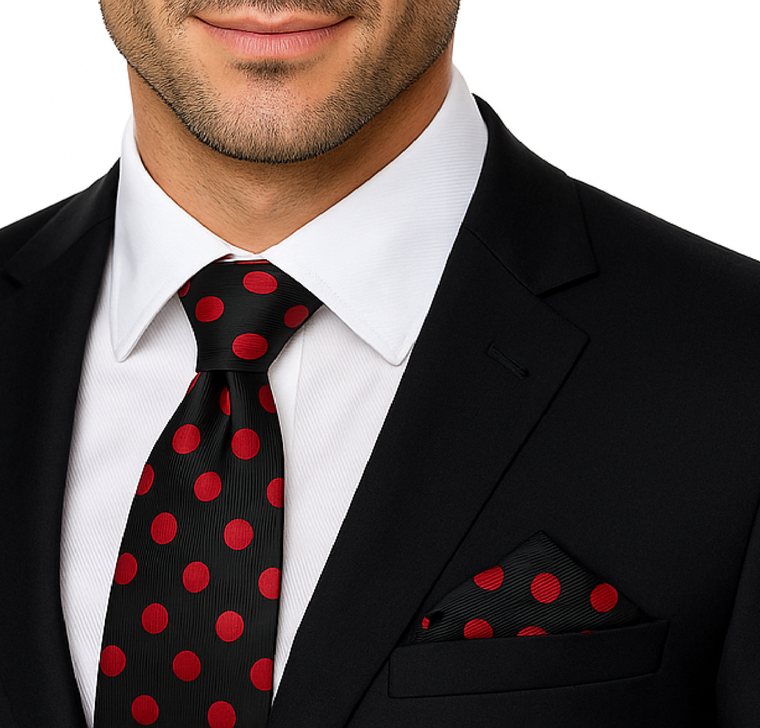 Man wearing a black suit with a red polka dot tie and pocket square on a white background