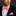 Man wearing a black suit with a pink bow tie and matching pocket square on a dark background