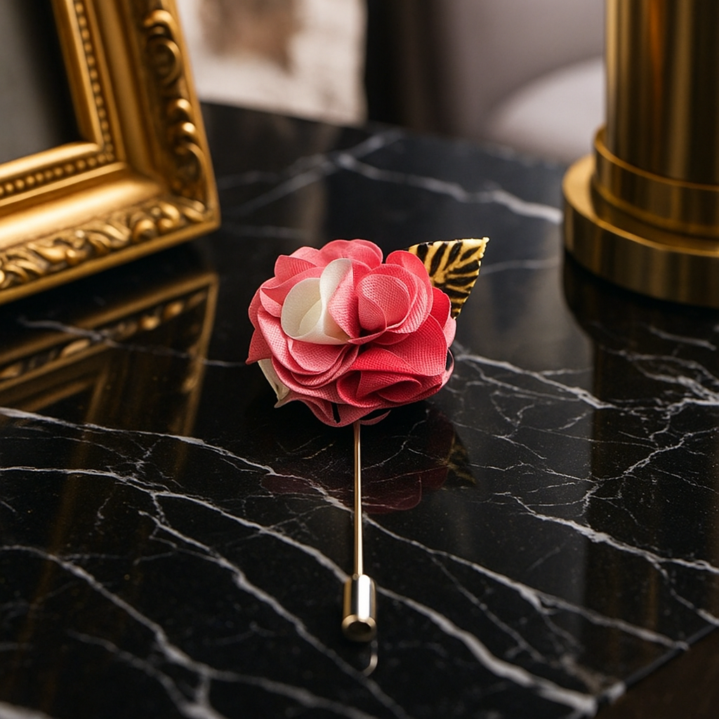 Pink and white floral lapel pin on a black marble surface with gold frame and column in the background.