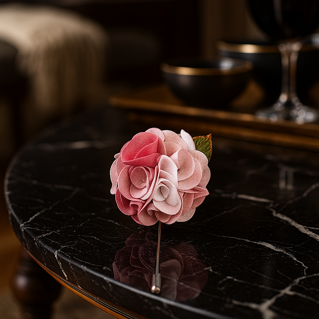 Pink flower brooch on a dark marble surface with blurred background
