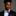 Man wearing a black suit with a colorful bow tie against a gray background