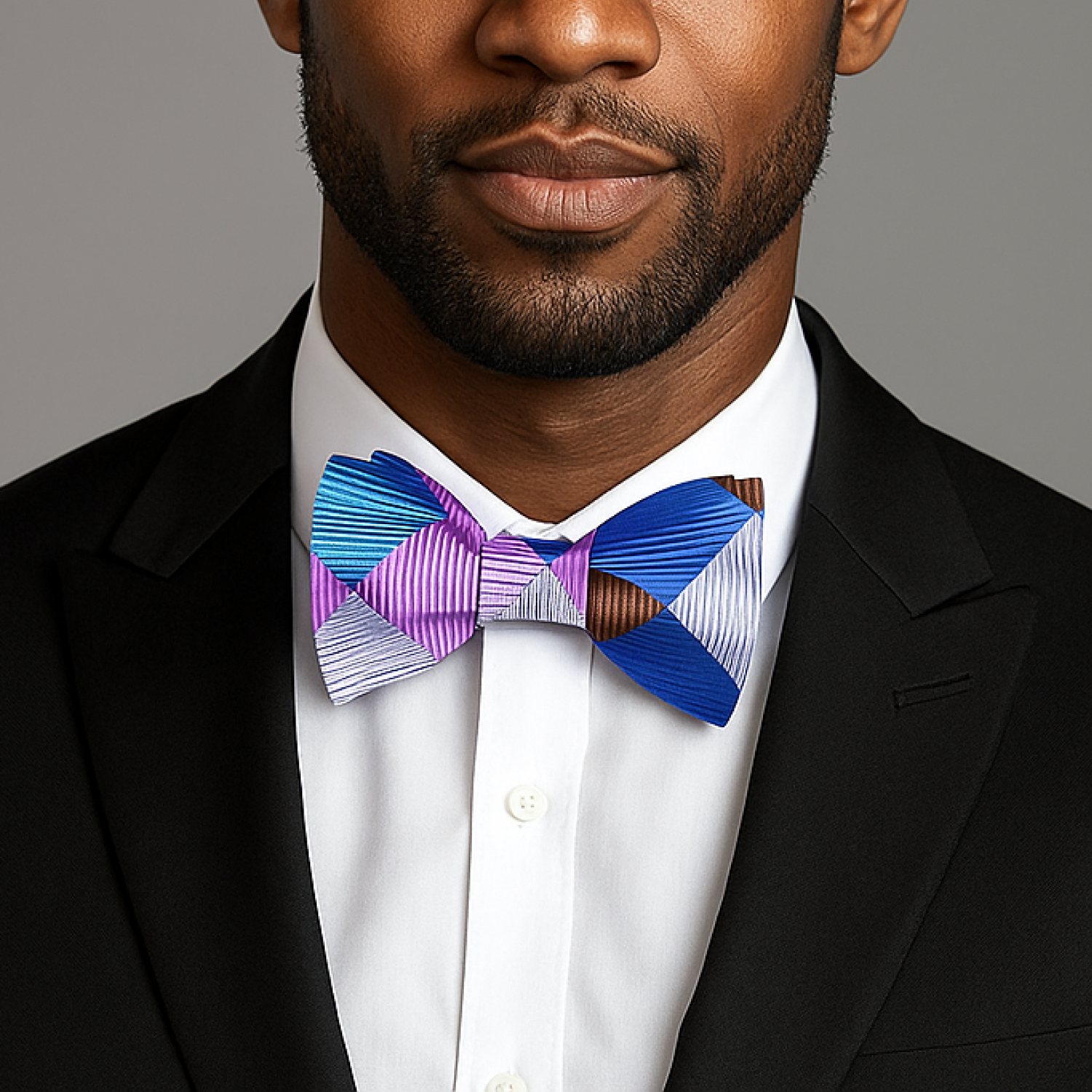 Man wearing a colorful bow tie against a gray background