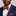Man wearing a blue suit with a colorful bow tie and pocket square against a gray background