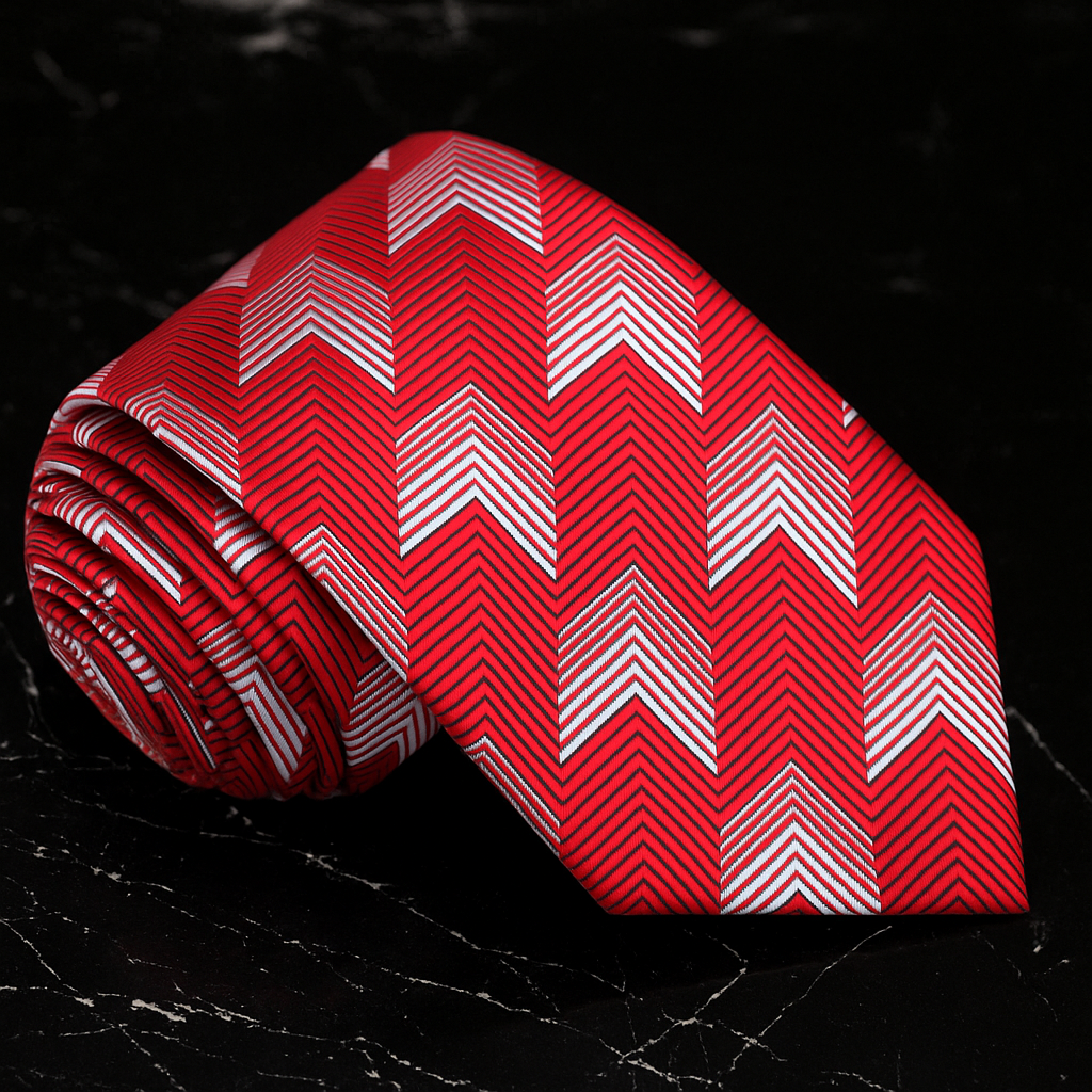 Red tie with white zigzag pattern on a textured black background
