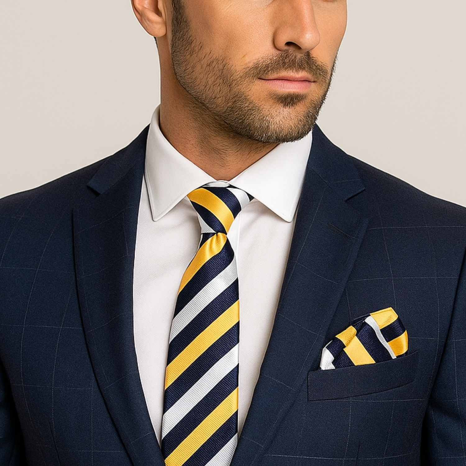 Man wearing a navy suit with a yellow and blue striped tie and pocket square.