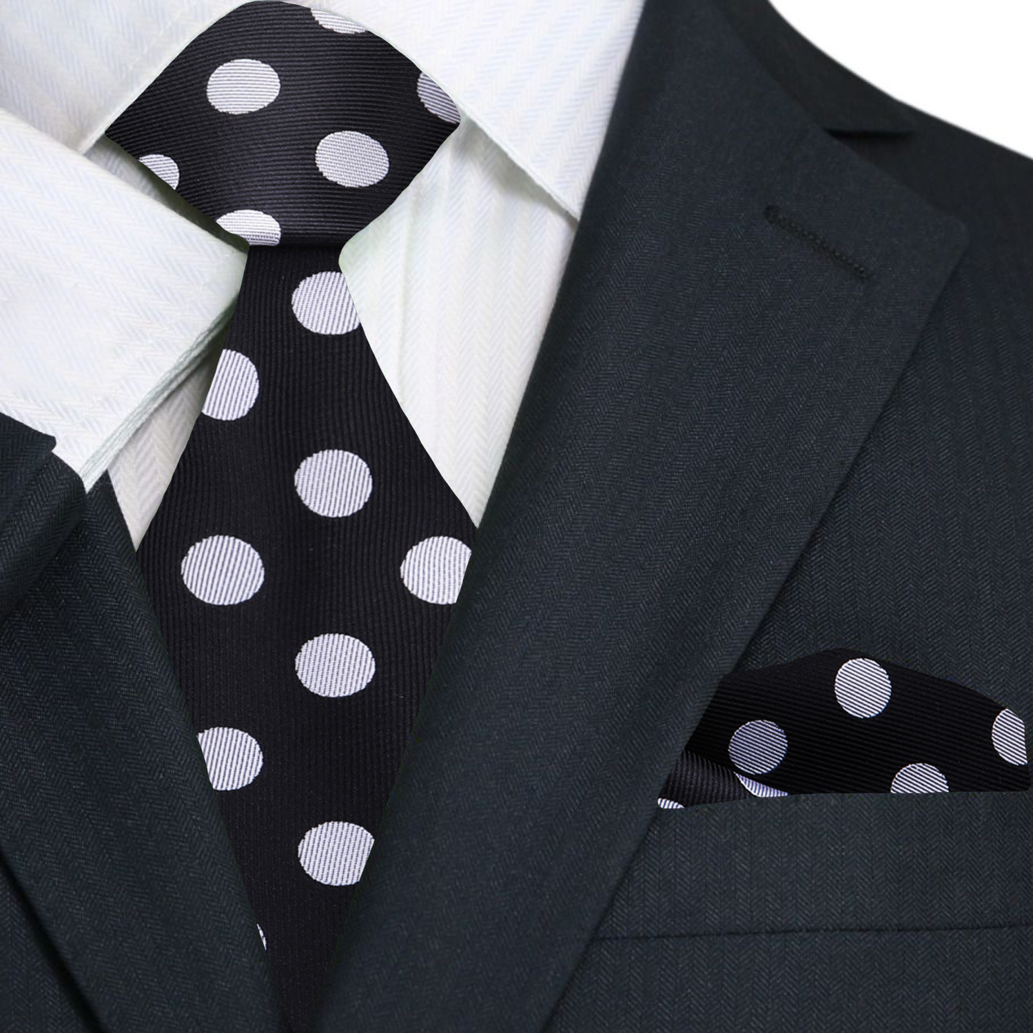 Black suit with a black and white polka dot tie and pocket square.