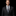 Man wearing a black suit with a striped tie on a black background