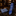 A blue patterned necktie and matching pocket square displayed on a dark marble surface in a warm, upscale shop setting.