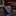 Roll of blue paisley tie on a marble surface with books and a mirror in the background