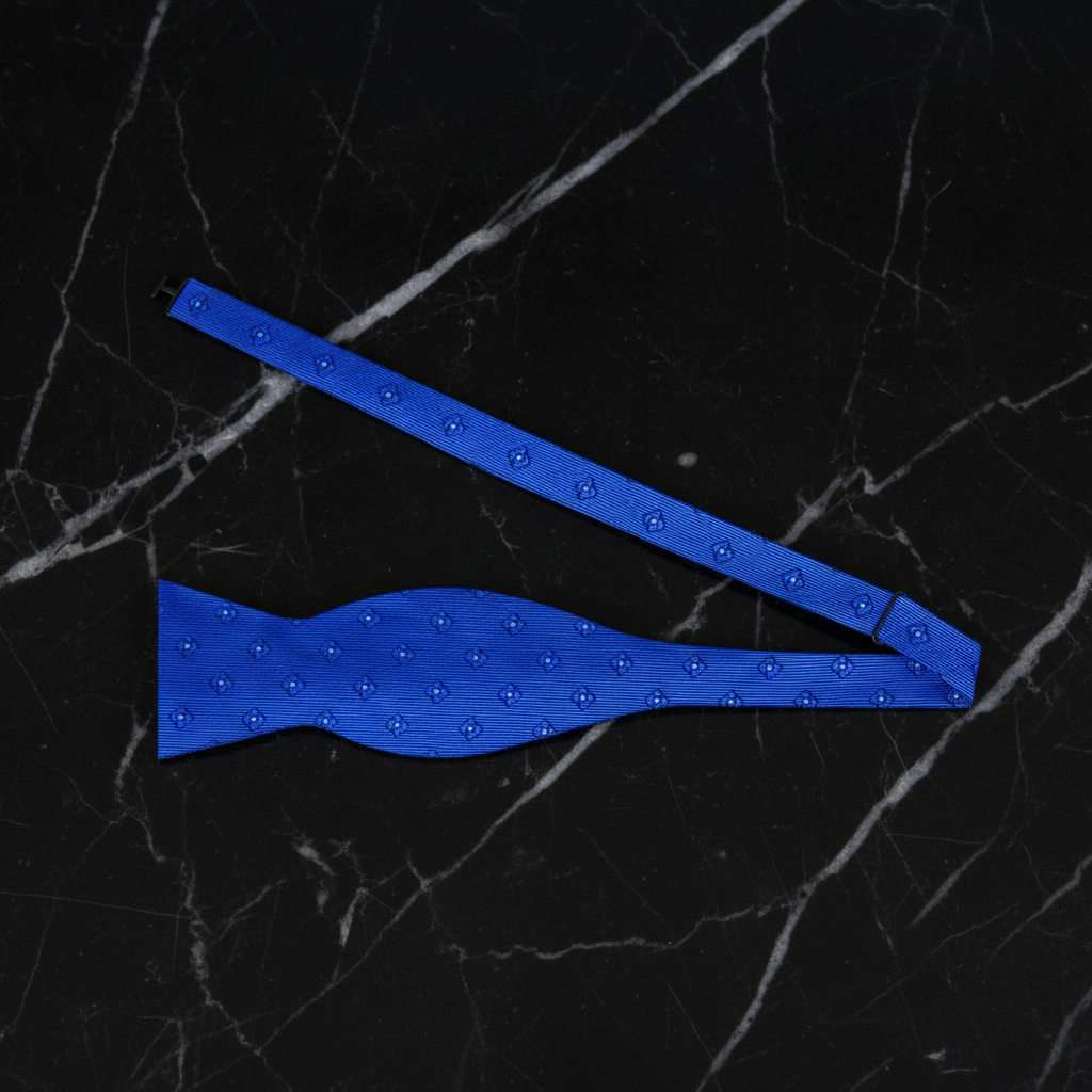 Blue bow tie with a textured pattern on a black marble background