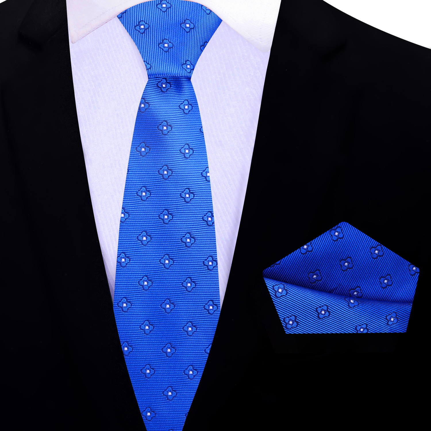 Blue patterned thin tie and pocket square set on a black suit jacket.