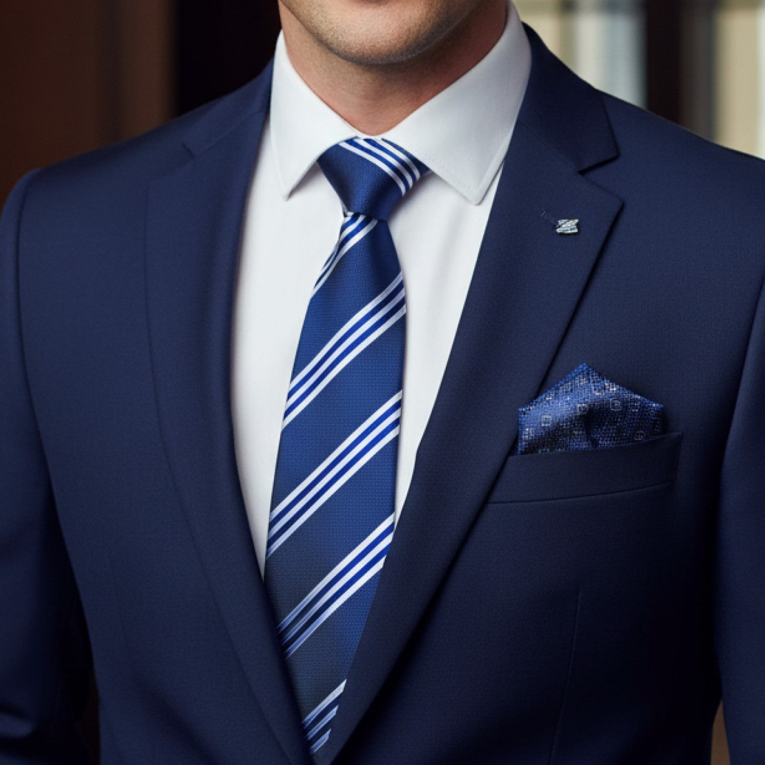 Man wearing a blue suit with a striped tie and pocket square.