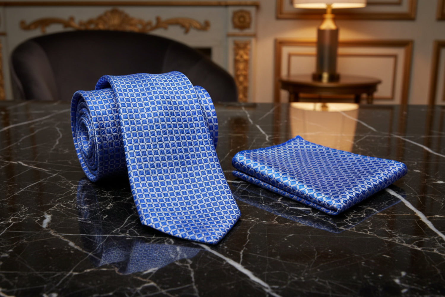 Blue patterned tie and pocket square on a marble surface with a blurred background