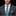 Man wearing a gray suit with a blue and gray patterned tie and pocket square on a black background