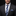 Man wearing a dark suit with a blue plaid tie and pocket square on a black background
