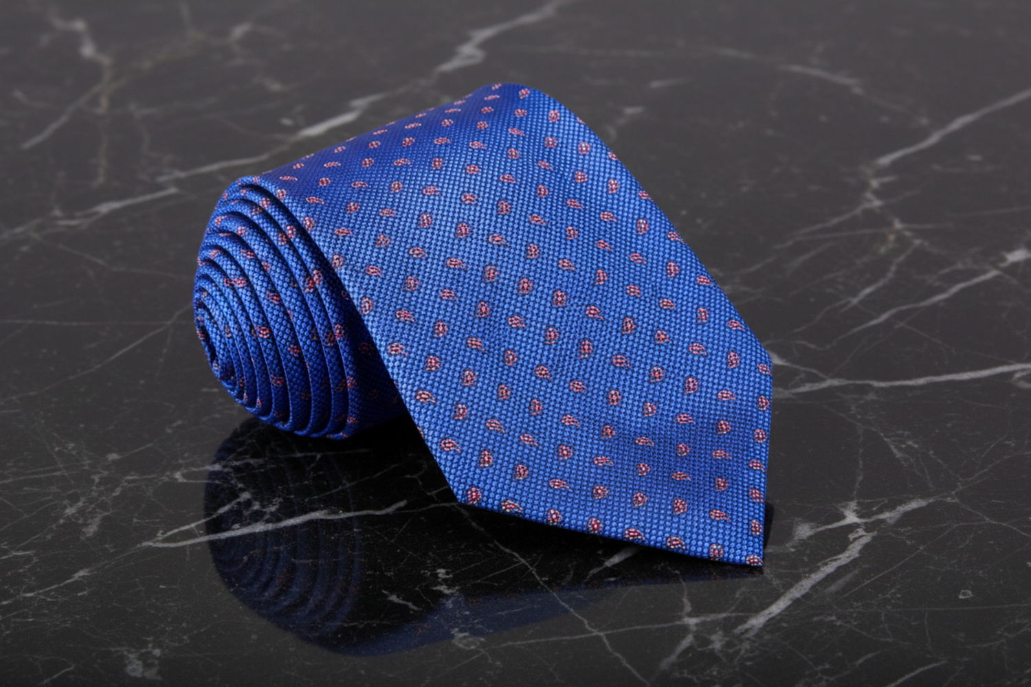 Blue tie with red dots on a black marble surface